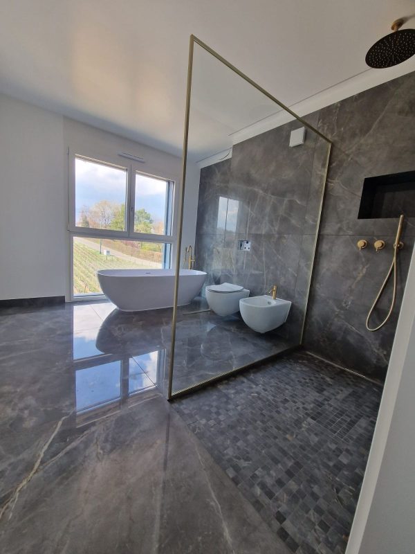 Douche à l'italienne avec paroi vitrée et baignoire îlot, sol en pierre foncée