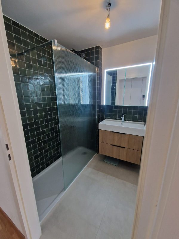 Douche à l'italienne vitrée avec faïence verte et meuble vasque en bois